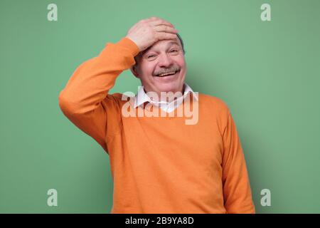 Happy man euphoric surprised by unbelievable offer on green wall Stock Photo