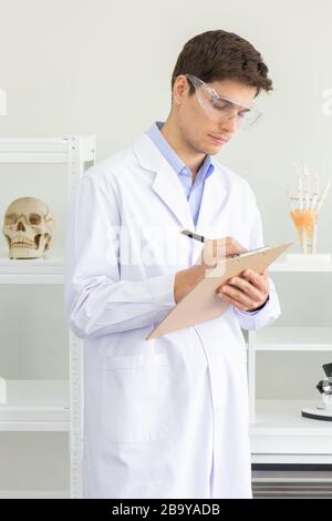 The concept of a new generation of scientific researchers notes data in a file in the laboratory. Young scientists are doing research. Stock Photo