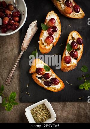 Crostini with goat cheese, grapes and rosemary Stock Photo - Alamy