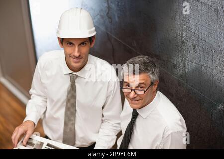 Architect in hardhat and client,  looking at architectural photos. Stock Photo