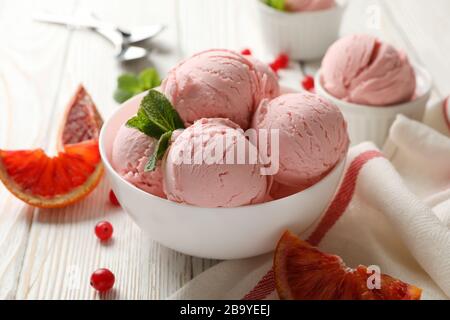 Bowls with ice cream balls on white wooden table, close up Stock Photo