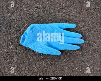 Munich, Bavaria, Germany. 25th Mar, 2020. A discarded protective glove, a now-common sight seen in Munich, Germany in supermarket parking lots, as well as train stations and other places where people still convene. Credit: Sachelle Babbar/ZUMA Wire/Alamy Live News Stock Photo
