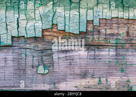 Background of peeled old green paint on a wooden surface, abstraction of old design. Stock Photo