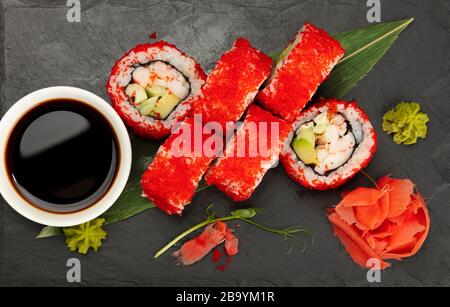 Close up set of six Boston or California sushi rolls served on black slate board, elevated top view, directly above Stock Photo
