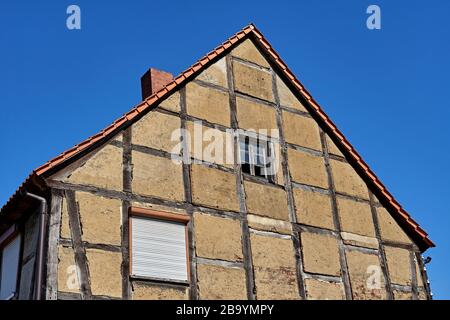 Old half-timbered house facade with exposed wooden beams. The old building is being restored Stock Photo