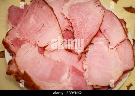 Traditional Easter breakfast, sliced cooked ham on the plate on the table. Stock Photo