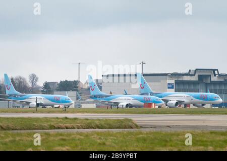 Glasgow, Scotland, UK. 25 March, 2020. Day two of the Government enforced lockdown in the UK. All shops and restaurants and most workplaces remain closed. Cities are very quiet with vast majority of population staying indoors. Pictured; Tui passenger aircraft remain grounded and parked at Glasgow Airport. Iain Masterton/Alamy Live News Stock Photo
