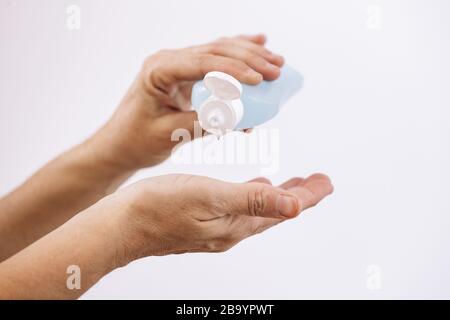 disinfecting hands with alcohol isolated on white background, hygiene concept and protection against viruses and bacteria Stock Photo
