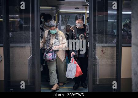 An elderly woman travelling on a bus wearing a face mask as a preventive measure during the corona virus pandemic.Hong Kong has so far reported a total of 410 confirmed cases of the COVID-19 coronavirus and 4 people have died as a result. Stock Photo