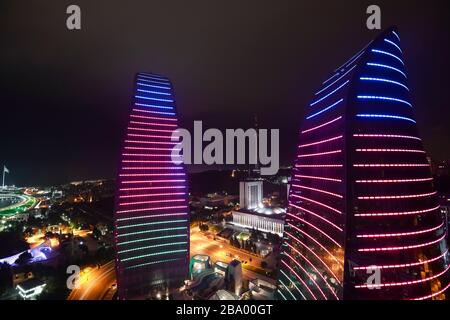 High point view of the Flame Towers skyscraper at night in Baku, Azerbaijan with illumination showing the Azeri flag colors. Modern construction. Stock Photo