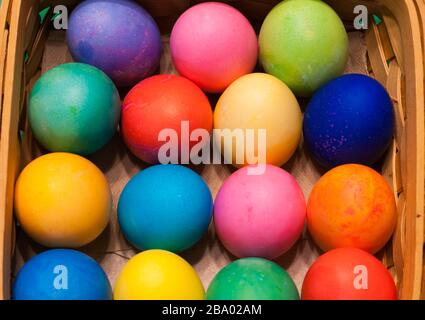Looking down on a basket filled with multi-colored dyed eggs Stock Photo