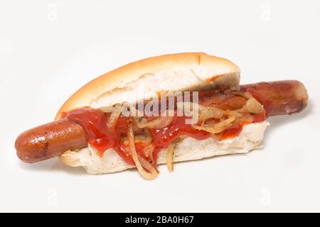 A homemade hot dog in a bun with fried onions and tomato ketchup. Dorset England UK GB Stock Photo
