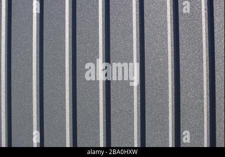 Greenery metallic fence made of corrugated steel sheet with vertical guides. Corrugated green iron sheet background close up. Stock Photo