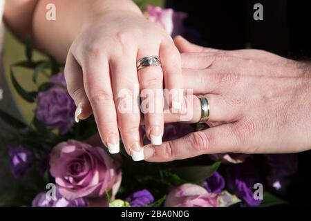 bride and groom with their wedding rings on, just married on their wedding day, just hands no faces Stock Photo