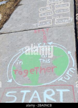 Sidewalk chalk art created to get people to stay home.  Message telling us that we are all in this together Stock Photo