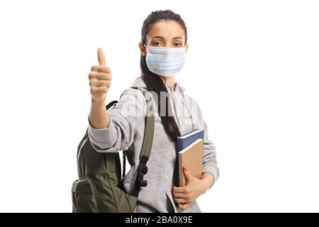 Female student with a medical face mask showing thumbs up isolated on white background Stock Photo