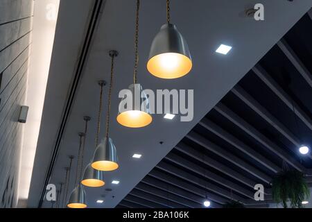 Modern lamps arrangement hanging on ceiling in restaurant Stock Photo