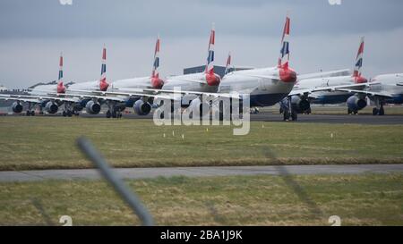 Glasgow, UK. 25th Mar, 2020. Pictured: British Airways Airbus Aircraft stand grounded on the tarmac at Glasgow Airport. The group of Airbus Aircraft comprise of Airbus A321, A320 and one A319 aircraft. Credit: Colin Fisher/Alamy Live News Stock Photo