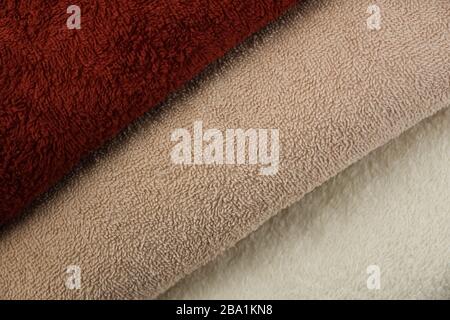 Soft texture of folded cherry and beige terry towels. Stock Photo