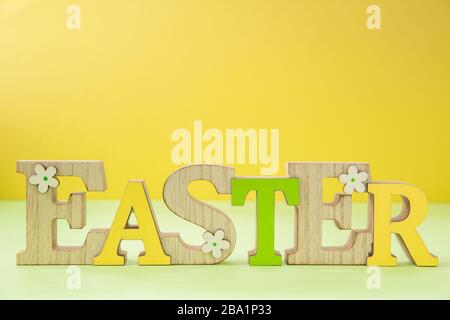 A colourful easter sign with seasonal flowers on a yellow background with copy space Stock Photo