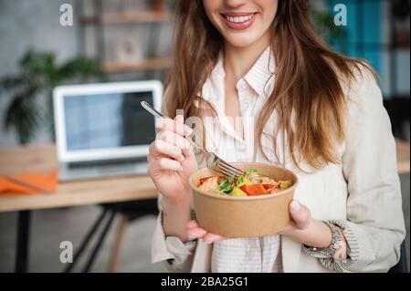 Woman holds a paper plate with food. Home delivery food. Healthy eating concept. When you stay at home. Stock Photo