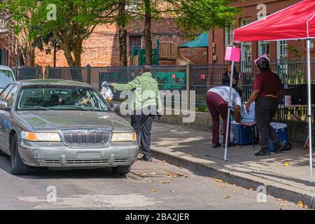 New Orleans, LA/USA - 3/21/2020: Volunteers Distributing Free Meals to Parents of School Children Forced to Stay Home Due to Covid-19 Pandemic Stock Photo