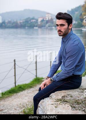 Young man wearing beside picturesque river or lake Stock Photo