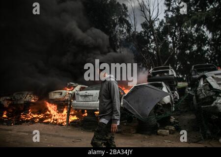 Tripoli, Libya. 25th Mar, 2020. A man is seen at a giant salvage yard which was attacked by Libyan National Army forces in Bou-Selim area, southern Tripoli, Libya, on March 25, 2020. Libya's east-based army said on Wednesday that the army has repelled an attack by the forces of the rival UN-backed government on Alwatya air base, some 130 km southwest of the capital Tripoli. Credit: Amru Salahuddien/Xinhua/Alamy Live News Stock Photo