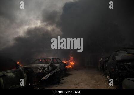 Tripoli, Libya. 25th Mar, 2020. Flames from burning cars are seen at a giant salvage yard which was attacked by Libyan National Army forces in Bou-Selim area, southern Tripoli, Libya, on March 25, 2020. Libya's east-based army said on Wednesday that the army has repelled an attack by the forces of the rival UN-backed government on Alwatya air base, some 130 km southwest of the capital Tripoli. Credit: Amru Salahuddien/Xinhua/Alamy Live News Stock Photo