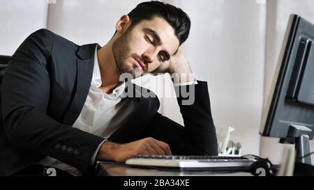 Tired bored young businessman in office Stock Photo