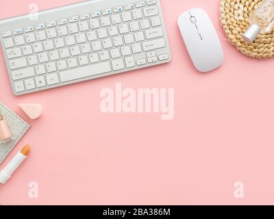 Freelancer woman blogger workplace, working space, keyboard, mouse laptop, perfume cosmetics bottles isolated on light pink table background with copy Stock Photo