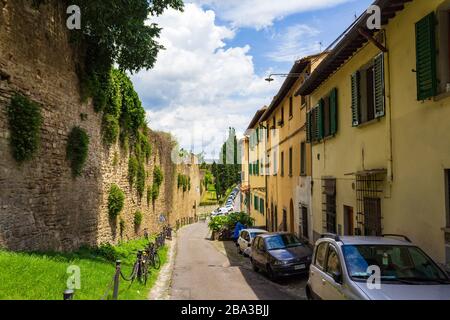 The road lined with traditional yellow houses leading to the Forte di Belvedere on the southbank of the River Arno in Florence, Italy Europe Stock Photo