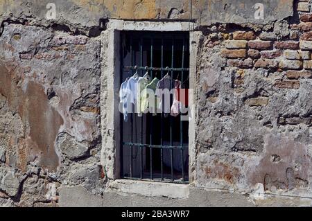 Baby clothes hanging outside a window in Venice Stock Photo