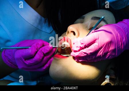 Young female patient takes a dental attendance in the dentist's office Stock Photo