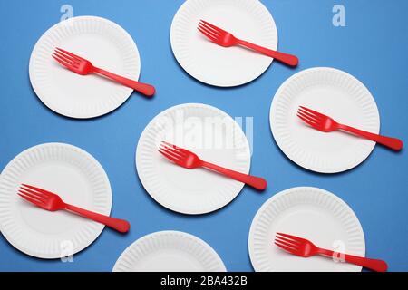 Paper Plates and Plastic Forks on Blue Background Stock Photo