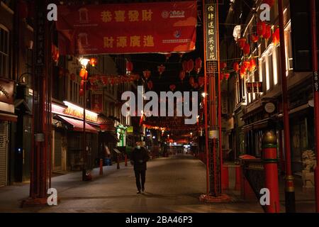 London, UK: At the heart of China Town in the West End only one restaurant remains open, serving take away food. The streets are deserted in the evening because of the covid-19 lockdown. Stock Photo