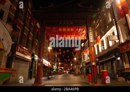 London, UK: At the heart of China Town in the West End only one restaurant remains open, serving take away food. The streets are completely deserted in the evening because of the covid-19 lockdown. Stock Photo
