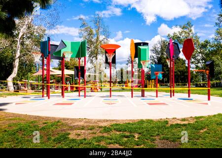 Los Angeles, California/USA - Yellow Caution tape, kids playground and basketball nets behind.  Kids playground closing on COVID-19 quarantine in CA. Stock Photo