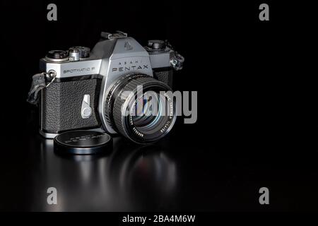 Saint John, NB, Canada - February 15, 2020: A Pentax film camera on a black table, with a black background. Stock Photo