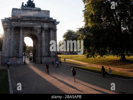 Architectural statues, monuments, London, Wellington Arch, Hyde Park Corner, A4, near Buckingham Palace, long shadows, pedestrians, walkway Stock Photo