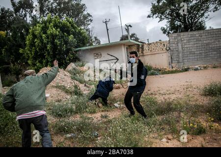 Tripoli, Libya. 25th Mar, 2020. UN-backed Government of National Accord (GNA) fighters wearing face masks engage with East-based Libyan National Army (LNA) forces during clashes at Ain-Zara frontline in Tripoli, Libya, March 25, 2020. The Minister of Health of Libya's UN-backed government, Ehmid Bin Omar, on Tuesday announced the first novel coronavirus infection in the country. Credit: Amru Salahuddien/Xinhua/Alamy Live News Stock Photo