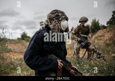 Tripoli, Libya. 25th Mar, 2020. UN-backed Government of National Accord (GNA) fighters wearing face masks take positions during clashes with East-based Libyan National Army (LNA) at Ain-Zara frontline in Tripoli, Libya, March 25, 2020. The Minister of Health of Libya's UN-backed government, Ehmid Bin Omar, on Tuesday announced the first novel coronavirus infection in the country. Credit: Amru Salahuddien/Xinhua/Alamy Live News Stock Photo