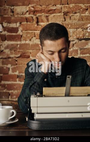 fine young writer working on a classic typewriter. he is happy and in no hurry Stock Photo