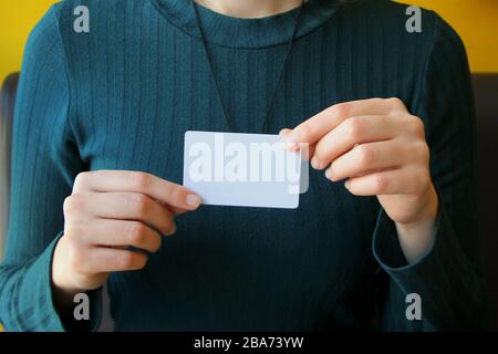 The girl holds a white rectangular card in her hands. Layout and mockup for design, place for text, copy space. Stock Photo
