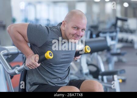 Young muscular man or trainer exercising in gym. Stock Photo