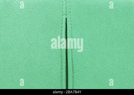 Background from green suede close up, zipper in the middle, full frame Stock Photo