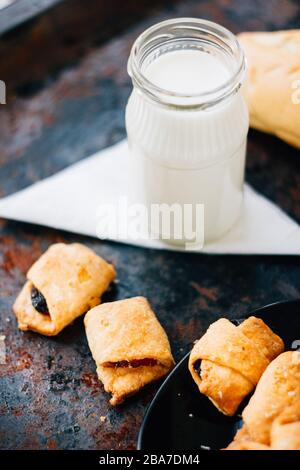 Nice breakfast - milk with croissants on black rustic surface Stock Photo