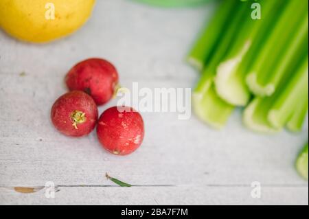 Kitchen - fresh colorful organic vegetables captured from above (top view, flat lay). Healthy vegetables on the table radish, celery and lemon on grey Stock Photo