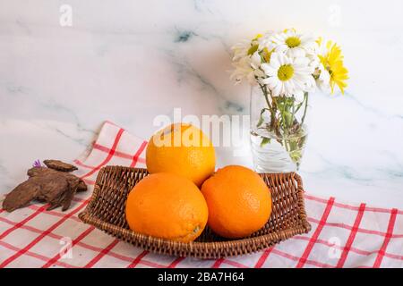 Oranges in a platter on the checked towel Stock Photo