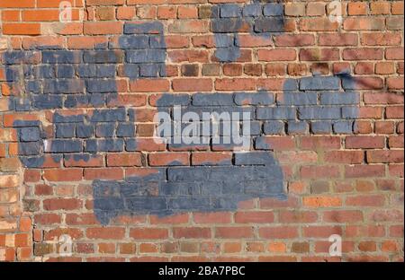 painted-over graffiti on a brick wall Stock Photo